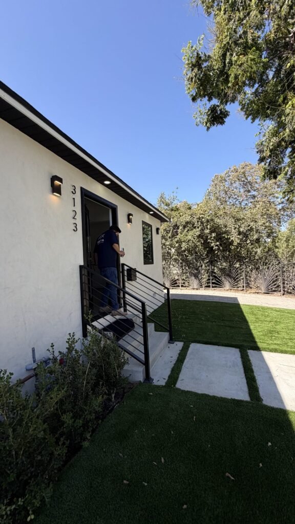 Side yard with artificial turf and concrete stepping stones - Rafa Home Builders