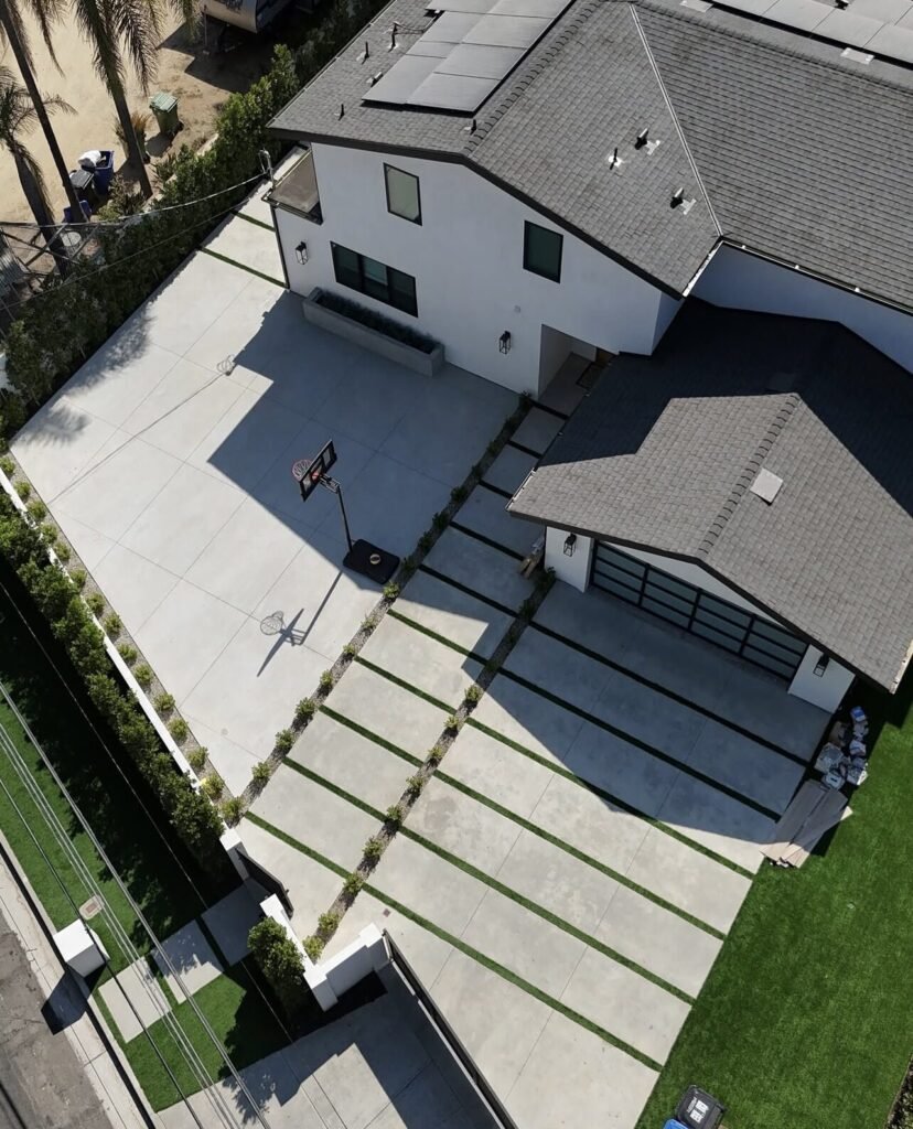Aerial view of a new home with concrete driveway and paver walkway - Rafa Home Builders