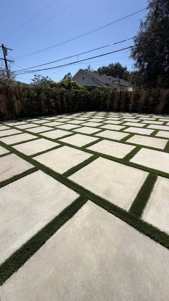 Large concrete pavers with artificial turf joints - Rafa Home Builders