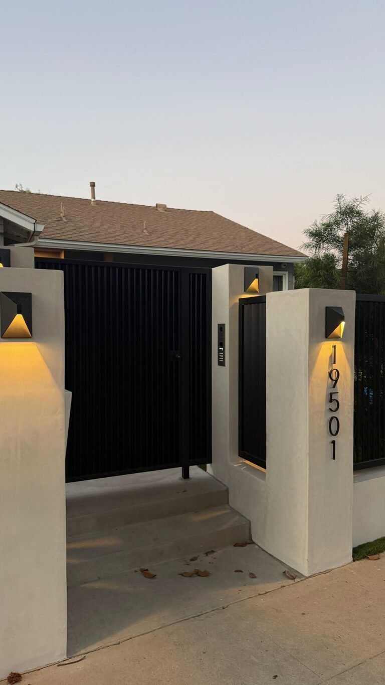 Stucco wall with a black metal fence and gate