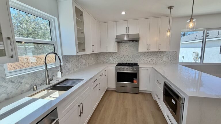 White kitchen with pendant lights and a farmhouse window