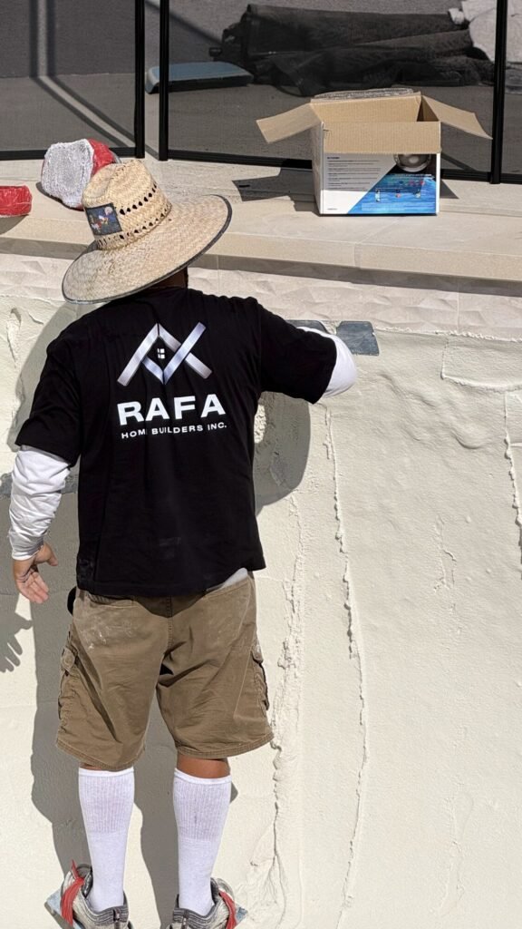 Crew applying new plaster to a swimming pool - Rafa Home Builders